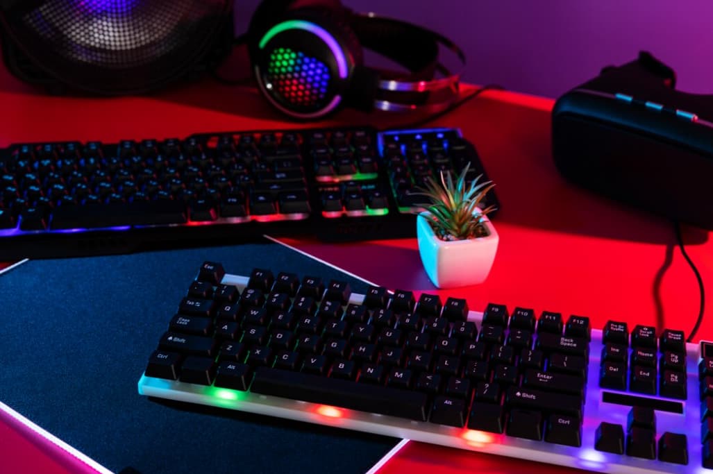 An illuminated gaming setup with a keyboard and mouse on a red-lit desk