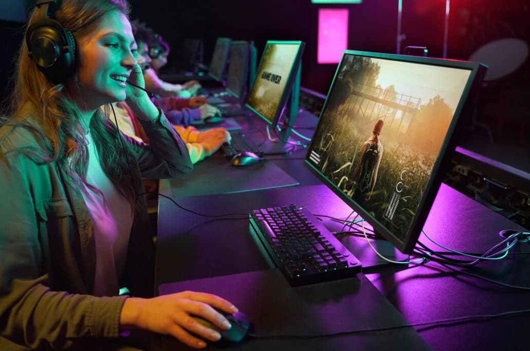 A happy gamer at a LAN party with others playing in the background