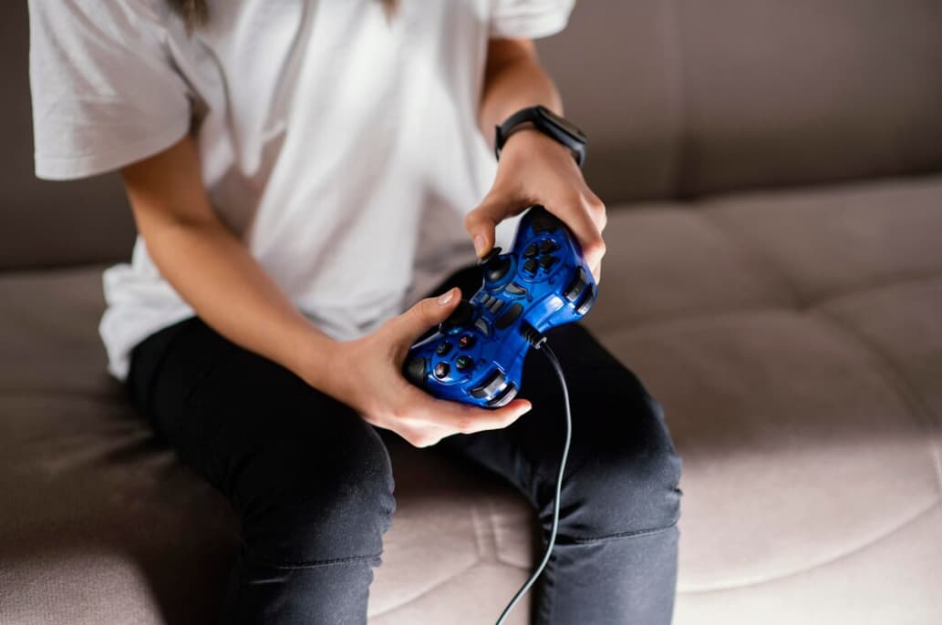 A person playing a video game with a blue controlle